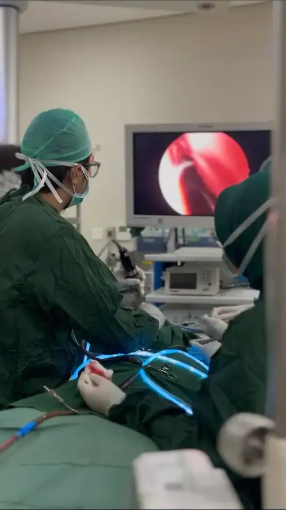 dr. Guntur memantau visualisasi endoskopi sinus di kamar operasi